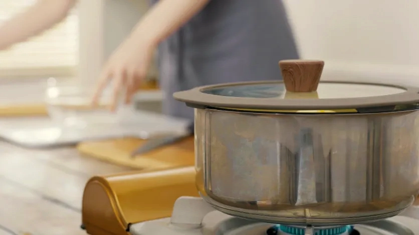 Pot simmering on a stovetop in sharp focus with a blurred background to show bokeh and guide the viewer’s gaze in video.