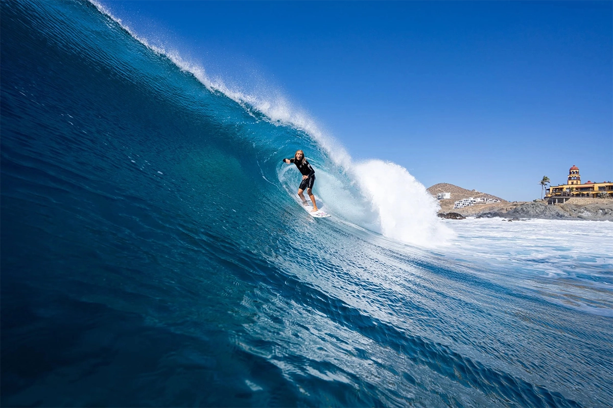 Fotografía de surf de un surfista montando una ola azul y limpia cerca de la playa de Cerritos, en Baja California.