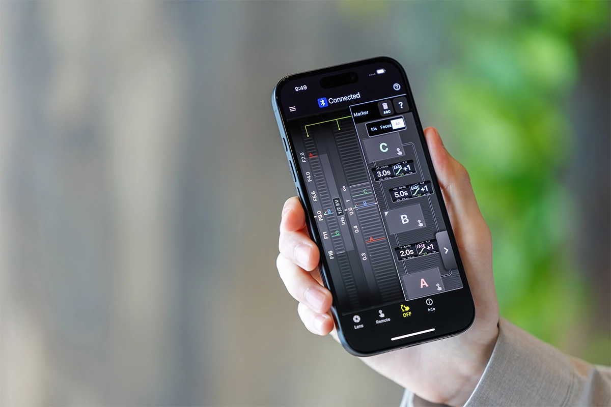 Tamron Lens Utility Interface de aplicativo móvel em um smartphone para personalizar as configurações da lente em dispositivos iOS e Android.