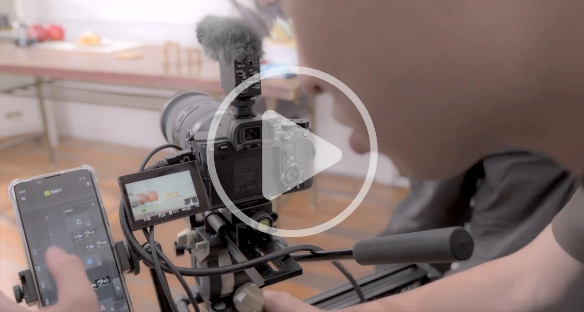 Behind-the-scenes view of a filmmaker adjusting focus on a camera rig using Tamron Lens Utility Mobile during the “Perfect Apple Pie” shoot.
