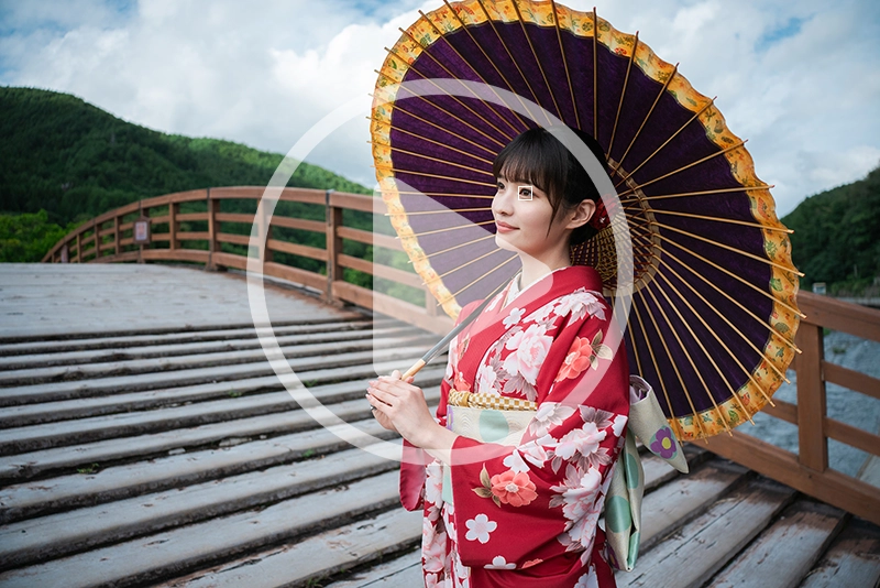 Portrait photo of a woman holding a traditional umbrella with an autofocus target overlay, illustrating fast subject tracking and focus accuracy.
