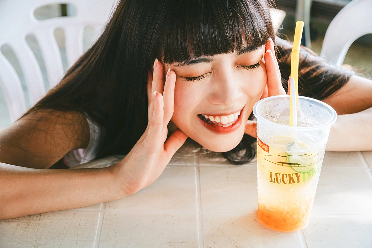 Cena de retrato de viagem Fujifilm X-mount com uma mulher relaxando em uma mesa com uma bebida gelada.