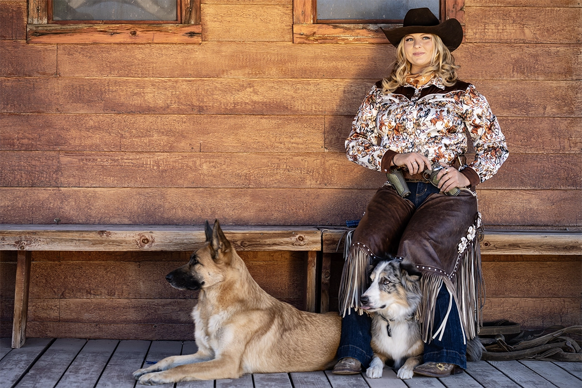 Retrato de uma vaqueira com dois cães fotografado com a lente Tamron 35-100 mm F/2.8 Di III VXD.