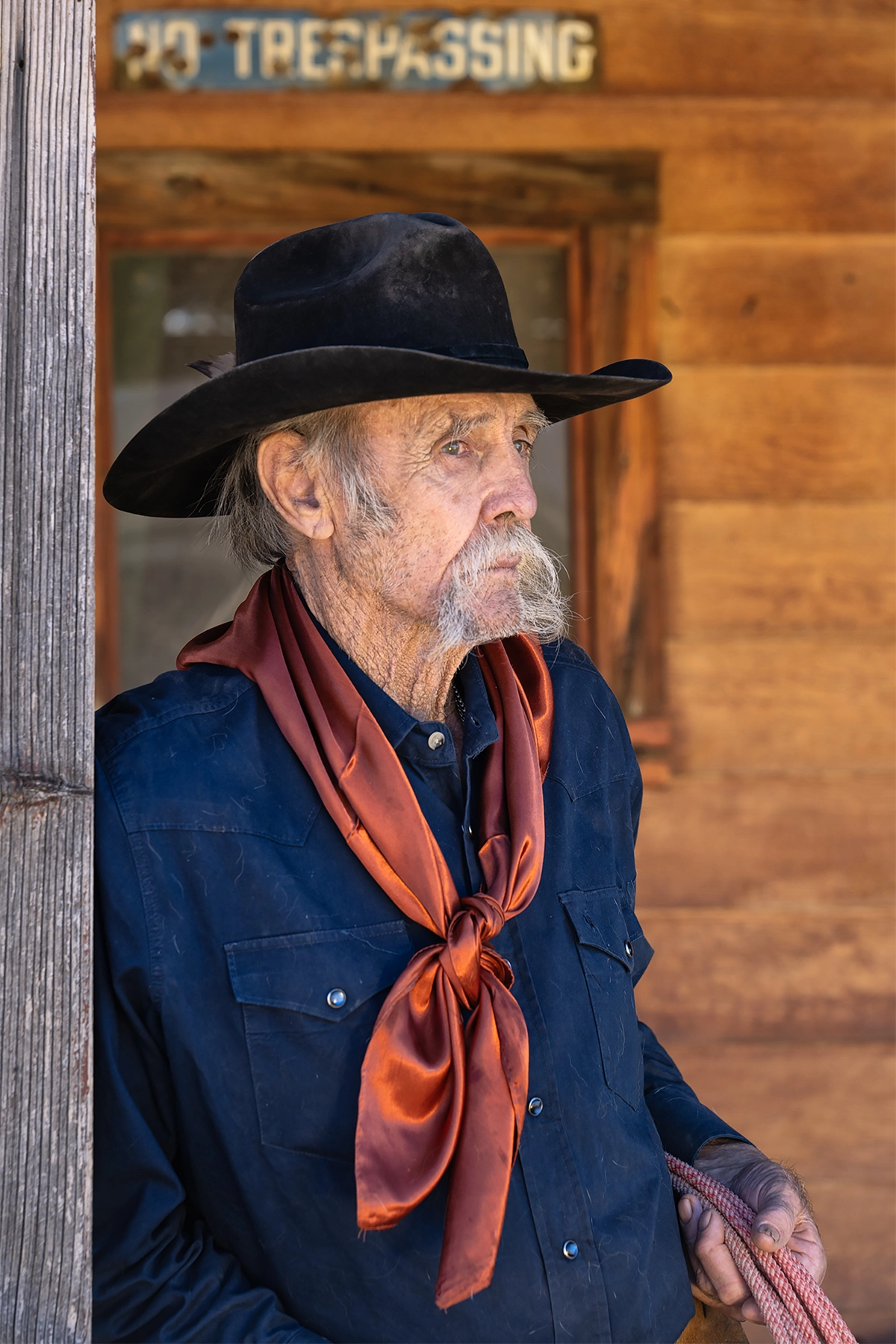 Retrato de um vaqueiro idoso usando uma bandana vermelha, fotografado com a lente Tamron 35-100 mm F/2.8 Di III VXD.