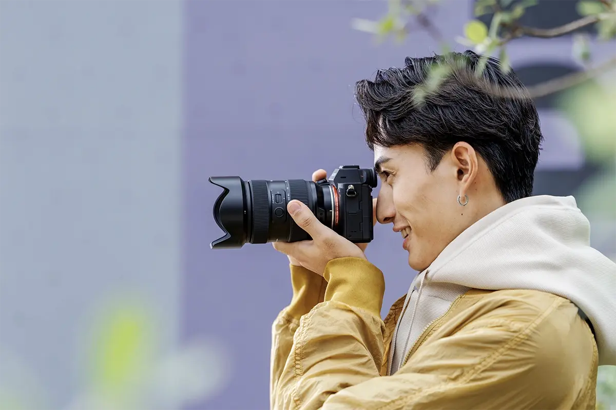 Photographer using the Tamron 35-100mm F/2.8 Di III VXD lens on a mirrorless camera for vacation photography.