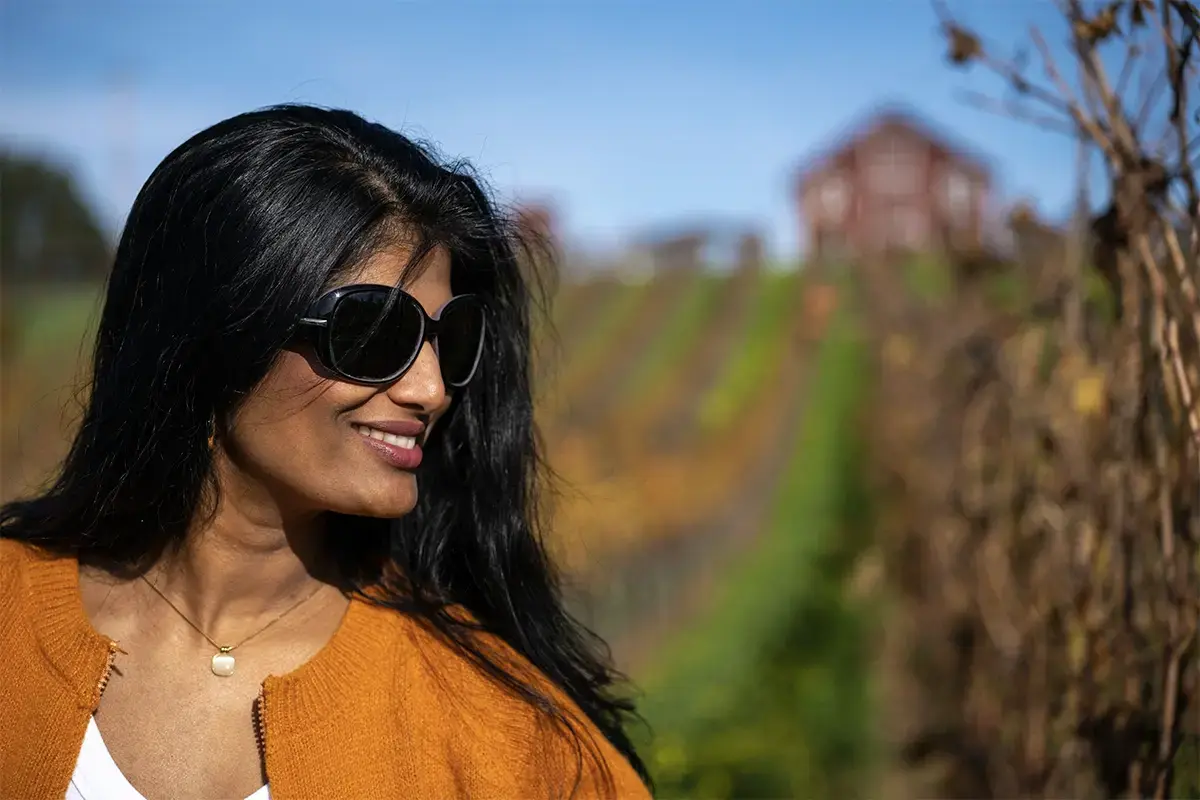 Candid portrait in vineyard rows photographed with the Tamron 35-100mm F/2.8 Di III VXD lens showing subject separation.