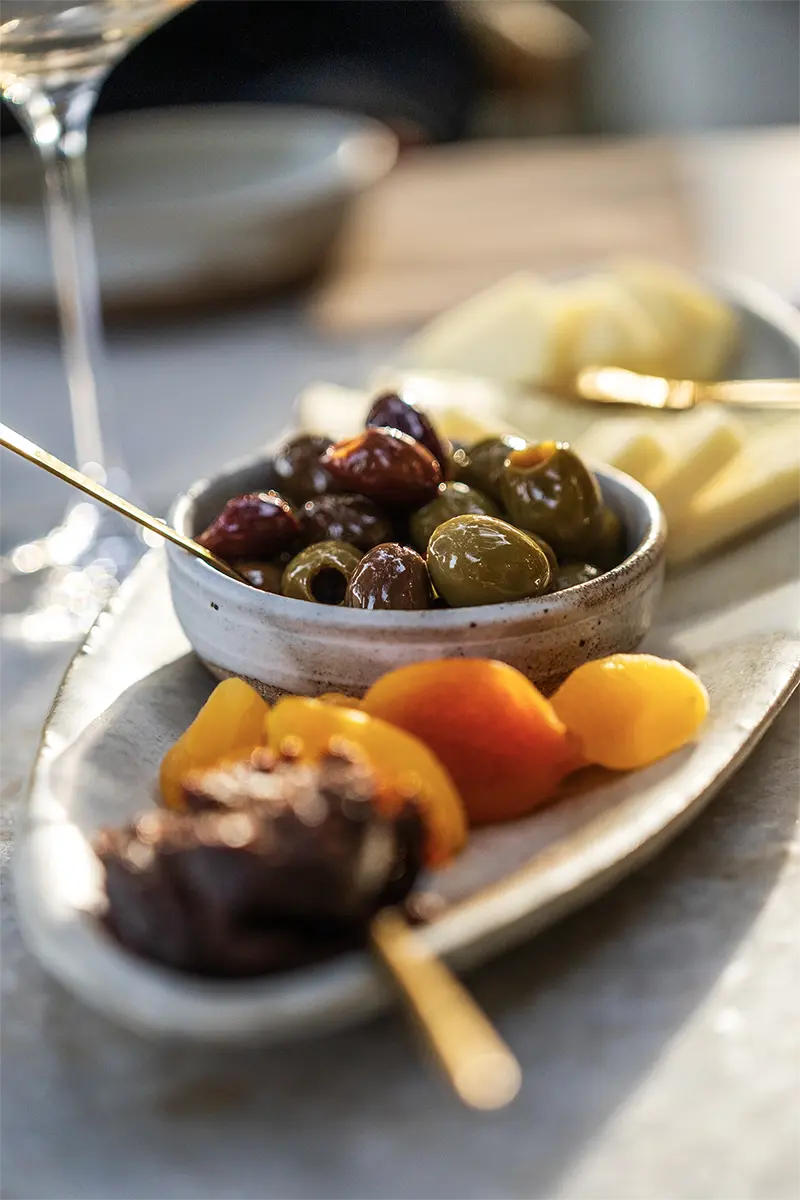 Close-up of olives and small plates at a winery photographed with the Tamron 35-100mm F/2.8 Di III VXD lens during a vacation.