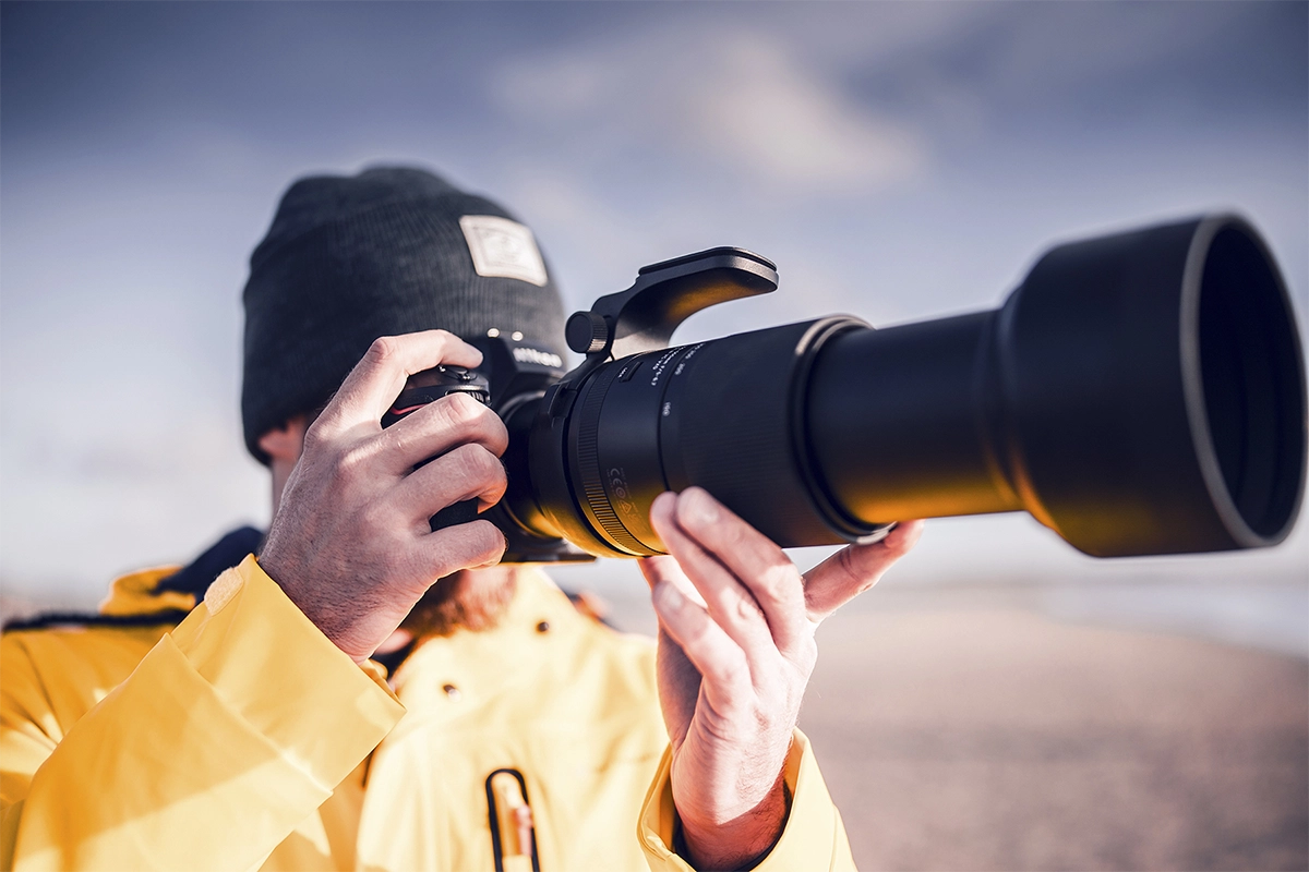 Fotógrafo que utiliza un teleobjetivo para capturar imágenes de la vida silvestre desde la distancia en condiciones naturales al aire libre.