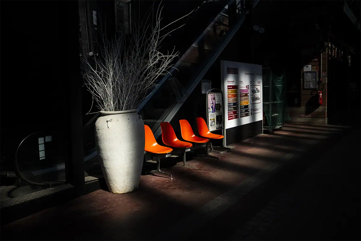 Escena interior con iluminación selectiva, sombras y un fuerte contraste visual.