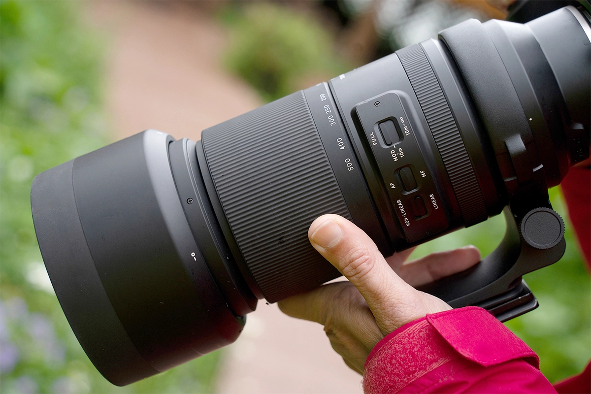 Primer plano de un teleobjetivo en el que se muestran los controles de enfoque, el rango de zoom y las funciones de control utilizadas en la fotografía de vida silvestre.