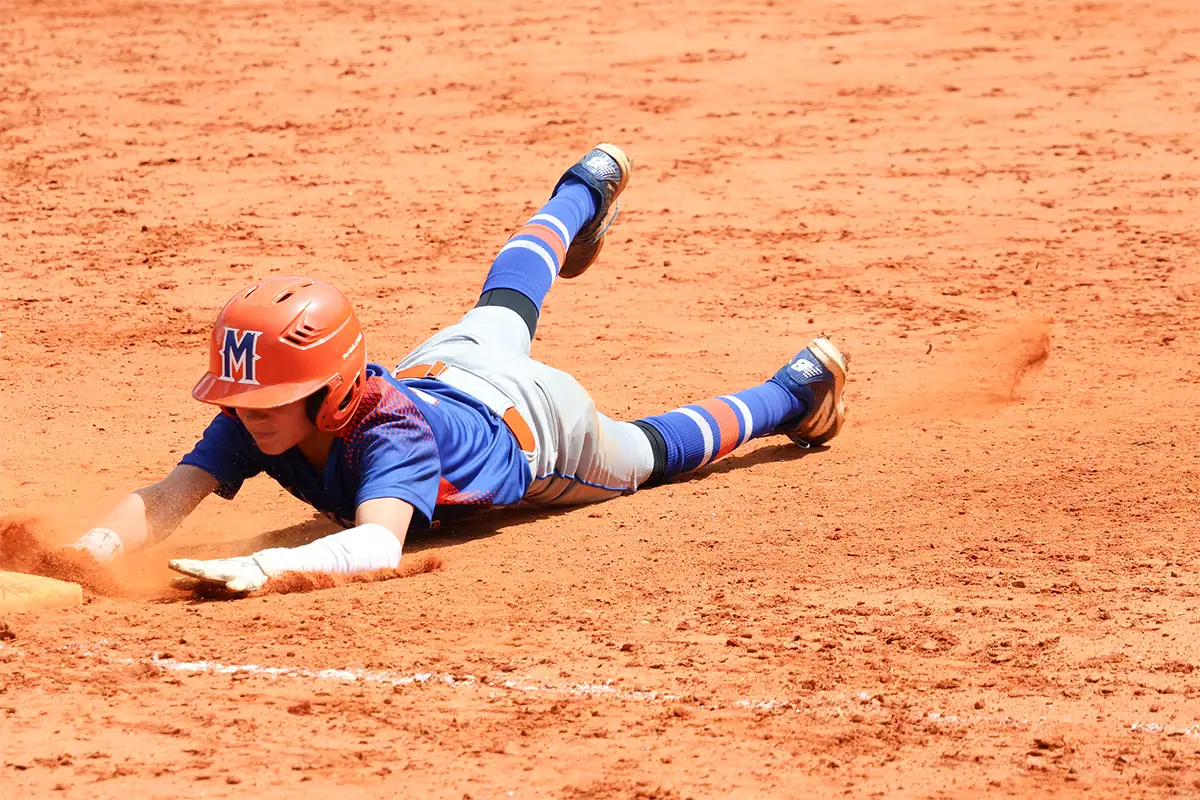 A baseball player dives toward base during a predictable sports action moment.