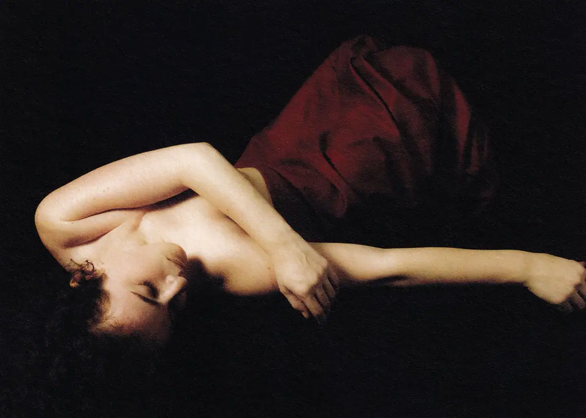 Une femme enveloppée dans une couverture rouge, allongée sur une table