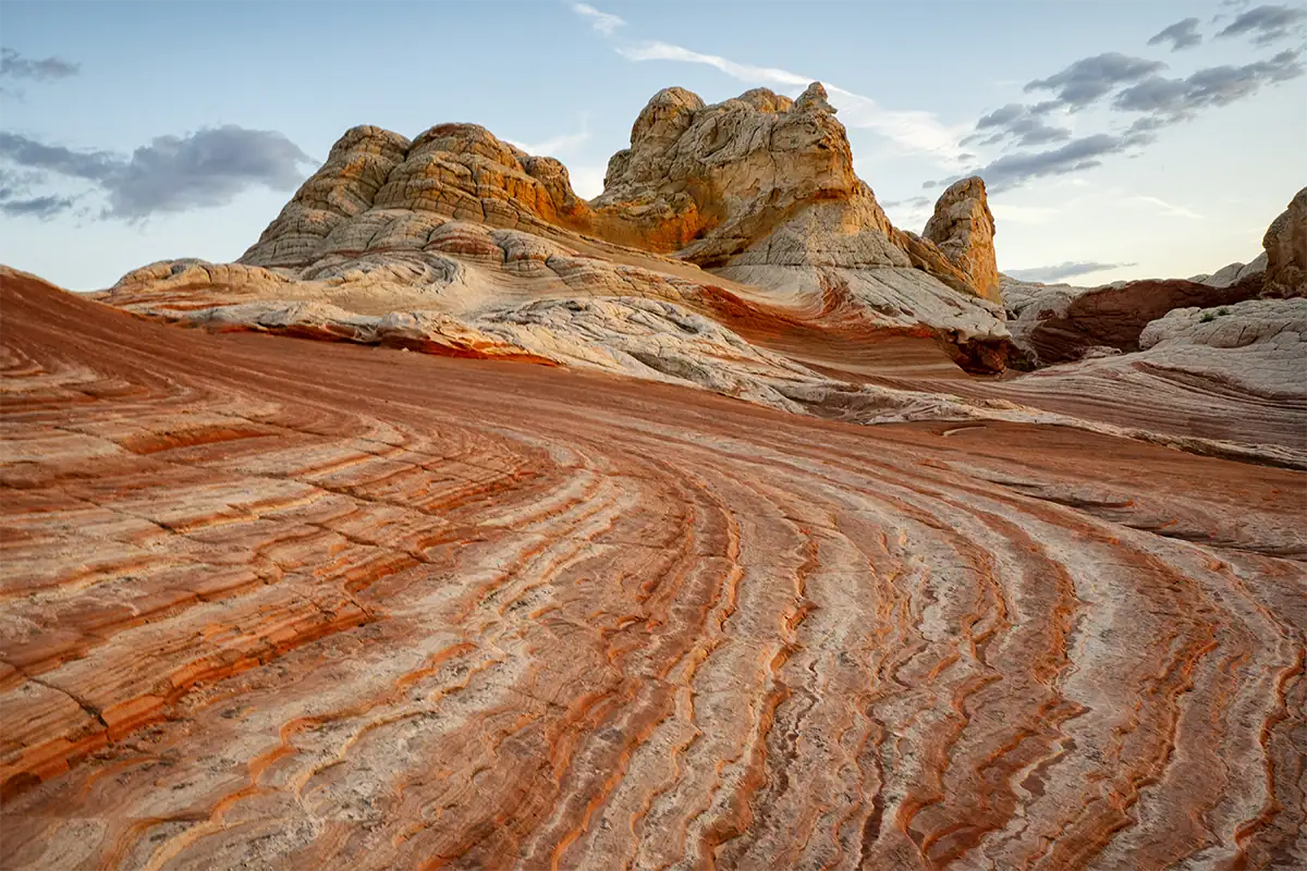 Red and white desert rock formations create strong texture, lines, and patterns across the foreground.