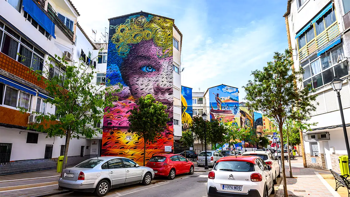 Colorful murals cover apartment buildings along a street in Fuengirola, photographed with the Tamron 16-30mm F2.8 G2 travel lens.