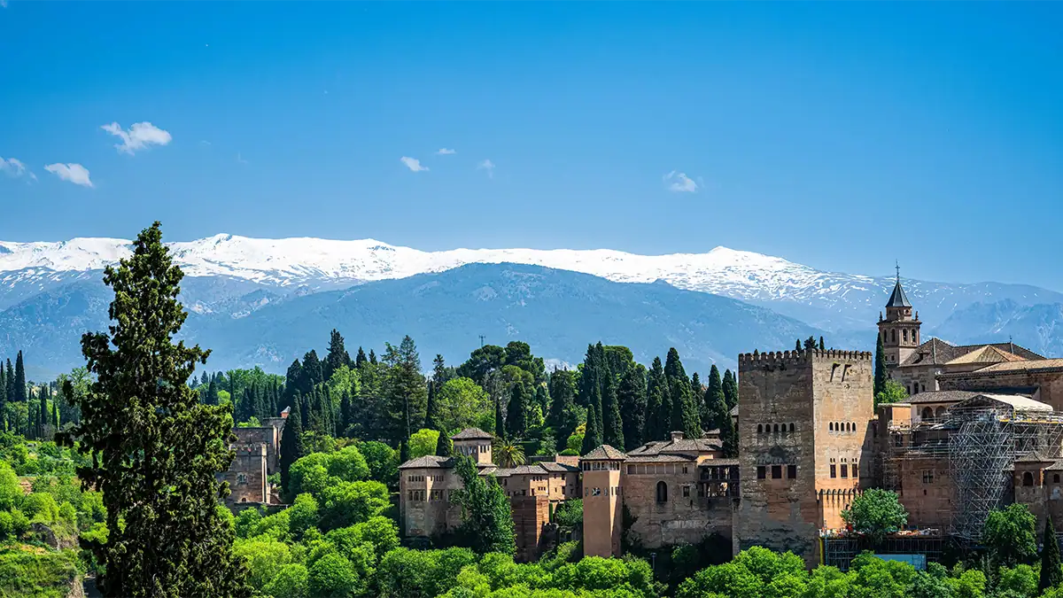 The Alhambra in Granada with the snow-capped Sierra Nevada mountains in the background, photographed with the Tamron 35-100mm F2.8 travel photography lens.