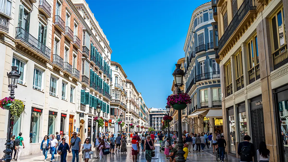People walk along a busy pedestrian street in Malaga, photographed with the Tamron 35-100mm F2.8 travel photography lens.