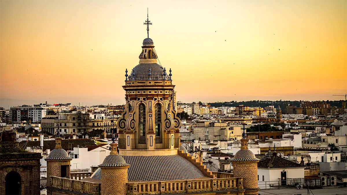 A Seville bell tower rises above the city skyline at sunset, photographed with the Tamron 35-100mm F2.8 travel photography lens.