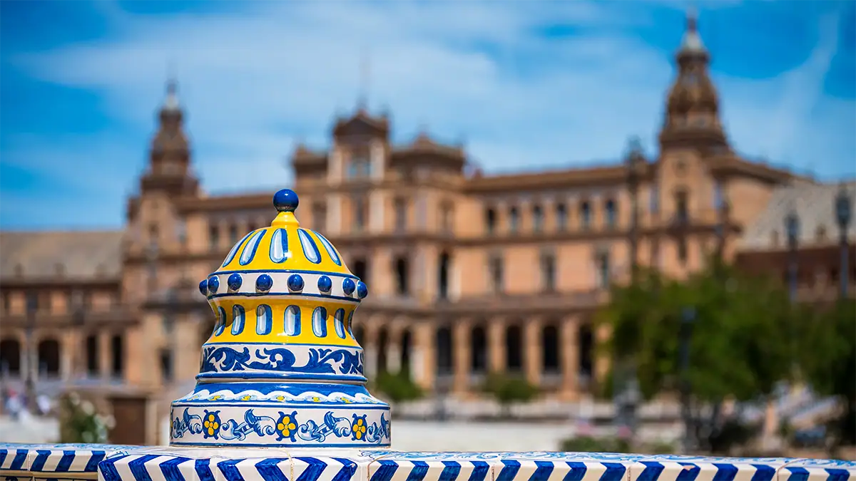 Decorative blue and yellow tilework at Plaza de Espa&ntilde;a in Seville with the architecture softly blurred behind it, photographed with the Tamron 35-100mm F2.8 travel photography lens.