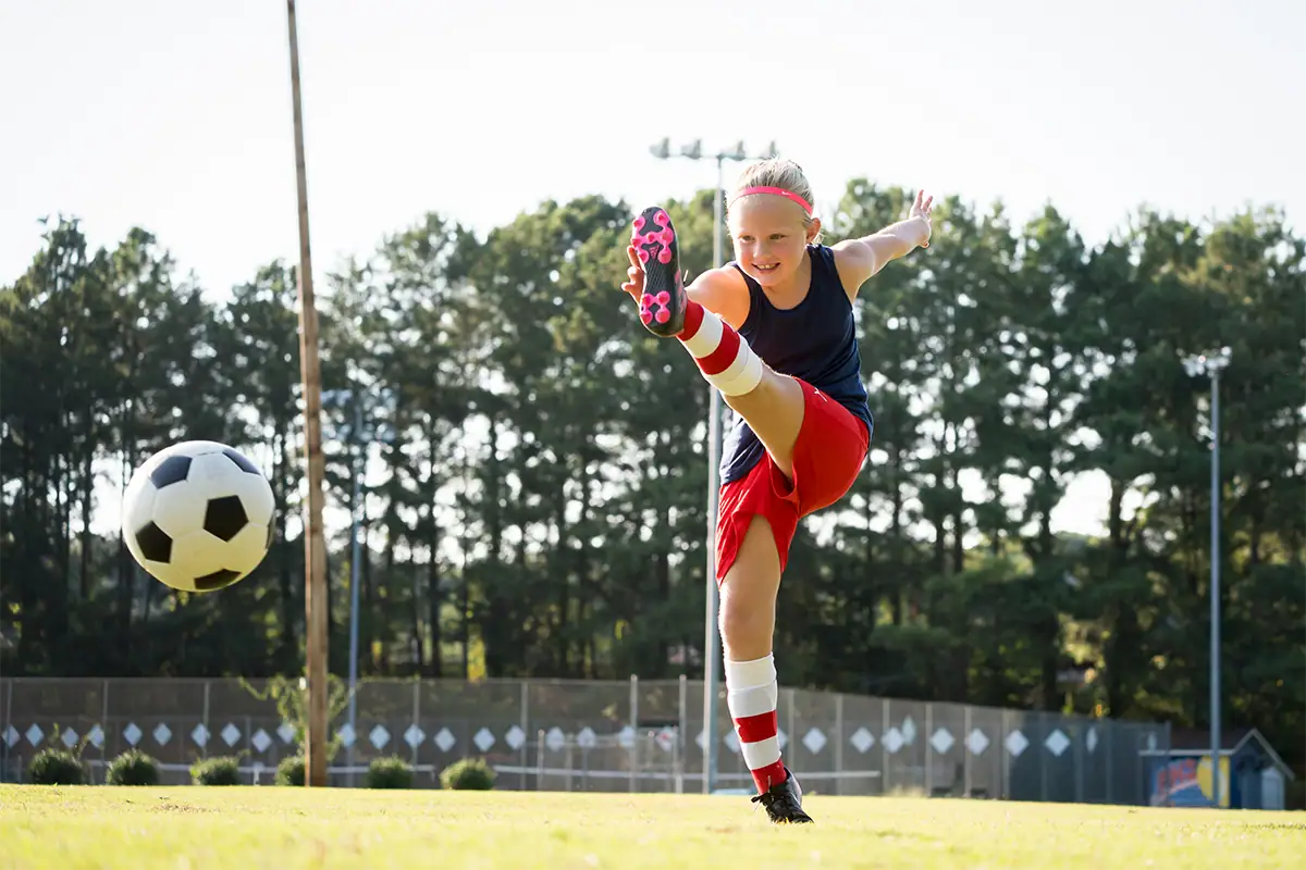 A young soccer player kicks the ball during an outdoor youth sports game.