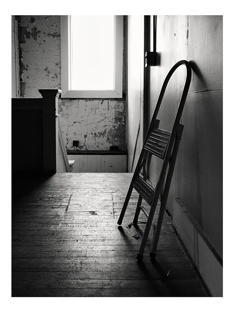 A step ladder leaning against the wall in a hallway