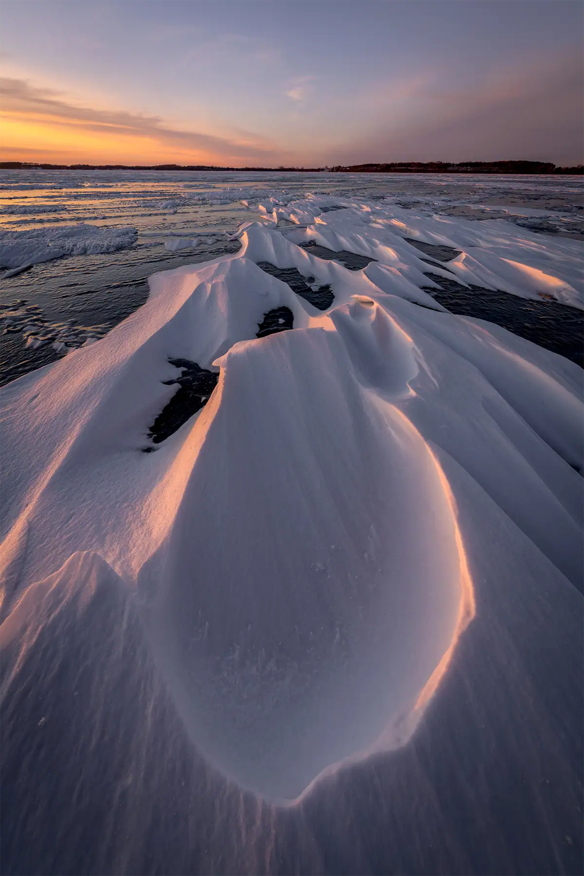 Frozen lake in Minnesota photographed with the Tamron 12-20mm F2.8 showing dramatic foreground snow formations.