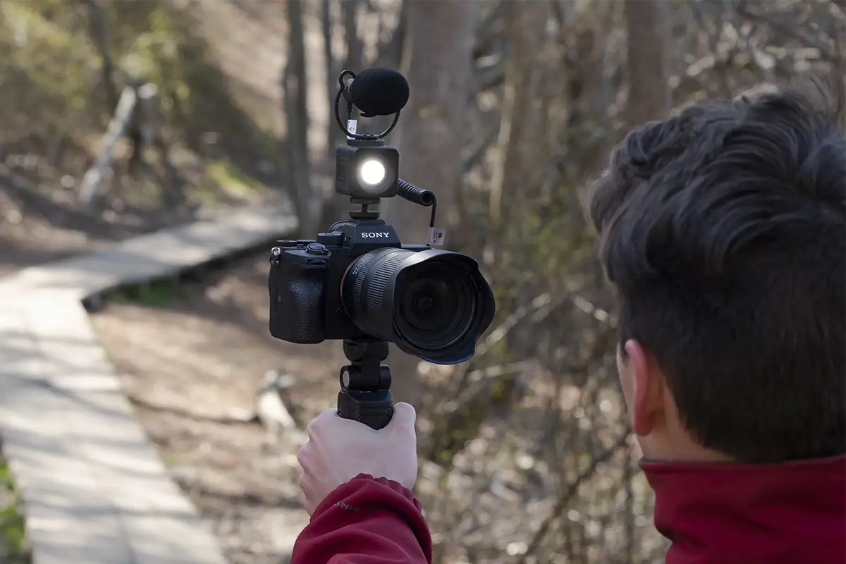 Creator kit with a Sony camera, Tamron lens, external microphone, LED light, and handheld tripod grip for video production.