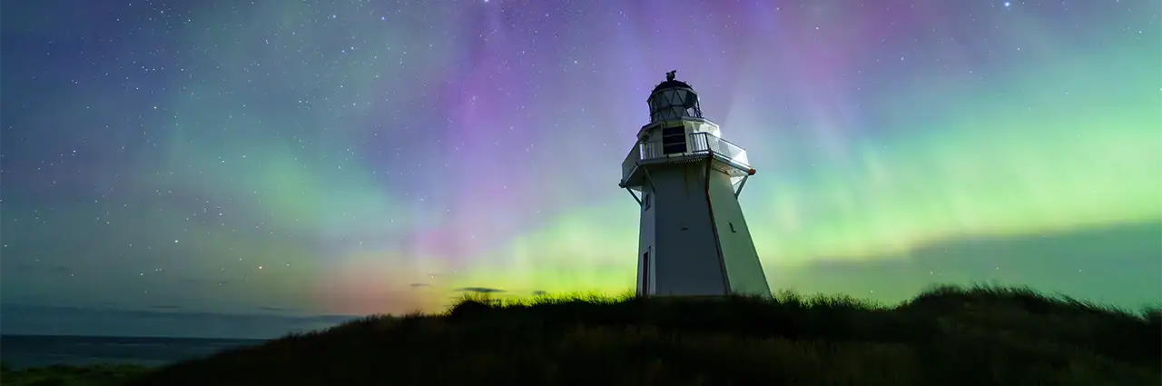 L'aurore boréale et la Voie lactée au-dessus du phare de Waipapa Point, en Nouvelle-Zélande, photographiées avec le Tamron 12-20 mm F2,8.