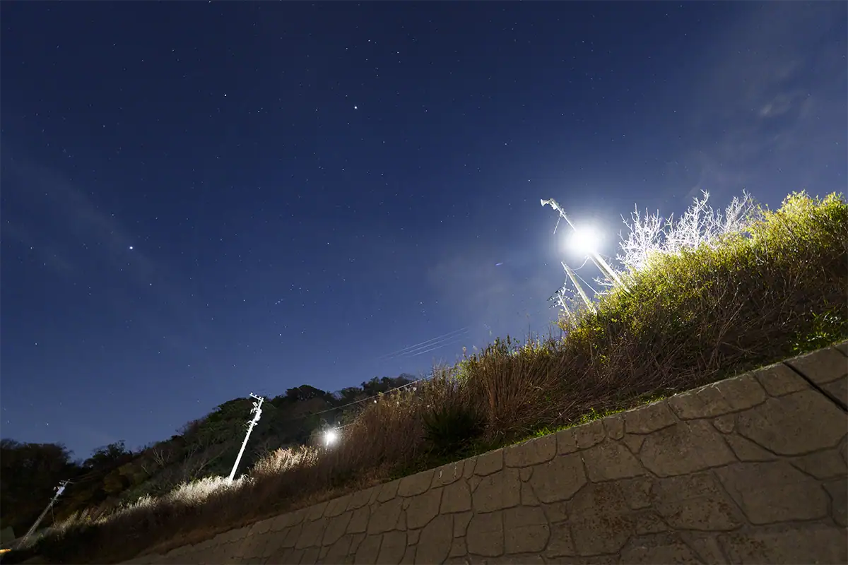 Un lampadaire LED très lumineux dans un paysage nocturne étoilé, utilisé pour évaluer les images fantômes et les reflets avec l'objectif Tamron 12-20 mm F2,8.