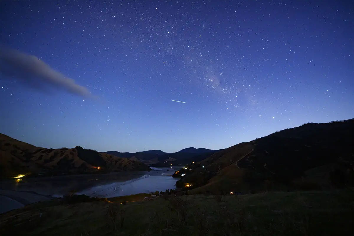 Des satellites Starlink traversent le ciel nocturne austral au-dessus des paysages néo-zélandais, photographiés avec le Tamron 12-20 mm F2,8.
