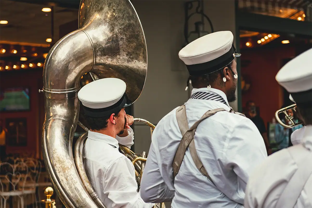 New Orleans marching band musicians photographed closely with a large brass sousaphone filling the frame at 50mm.