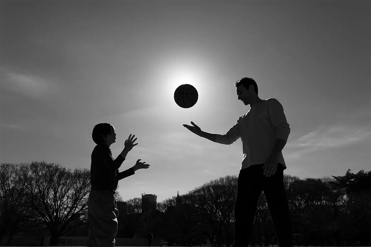 Father and child tossing a basketball in a black-and-white silhouette, photographed at 17mm with the Tamron 17-70mm F2.8.