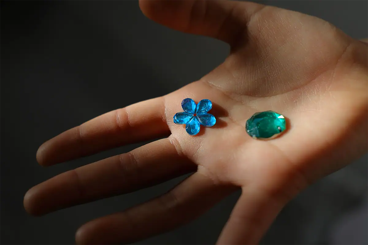 Close-up of a child's hand holding two colorful beads, photographed at 29mm with the Tamron 17-70mm F2.8.