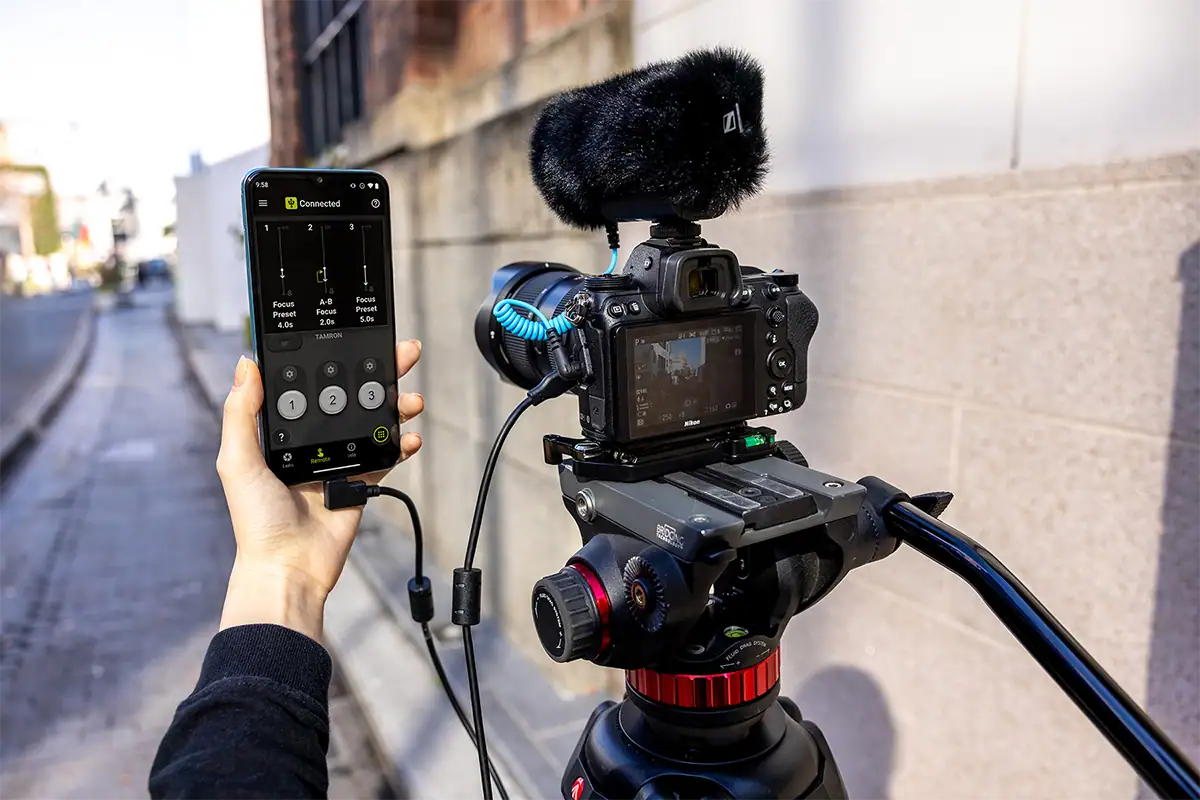 Créateur utilisant un appareil photo hybride équipé d'un objectif Tamron et d'un micro canon pour l'enregistrement vidéo.