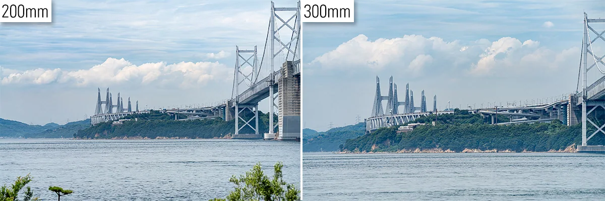 Comparação lado a lado da mesma cena de uma ponte distante, fotografada a 200 mm e 300 mm a partir da mesma posição, mostrando o maior alcance da teleobjetiva em 300 mm.