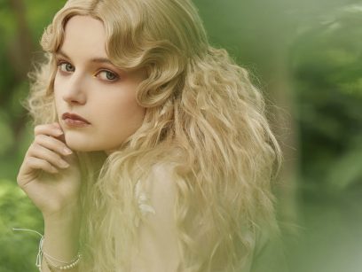 A close-up portrait of a woman with long blonde hair.